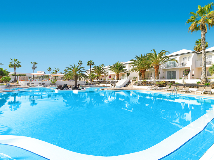 All inclusive resort met zwembad en ligbedden onder palmbomen
